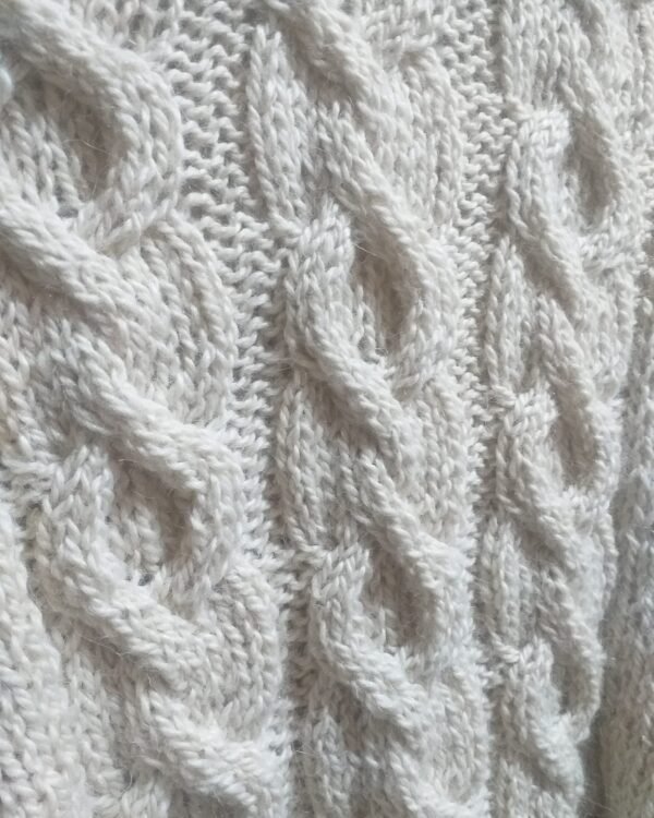 detalle de ochos de Ponchillo corto de alpaca con ochos y capucha. Alpaca auténtica , sedosa, suave con gran caida.